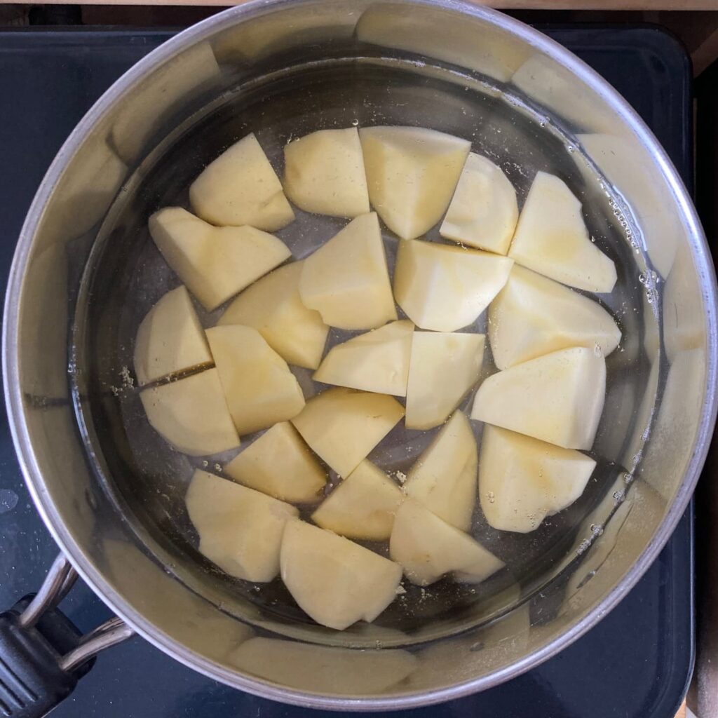 鍋で茹でている8等分にしたじゃがいも