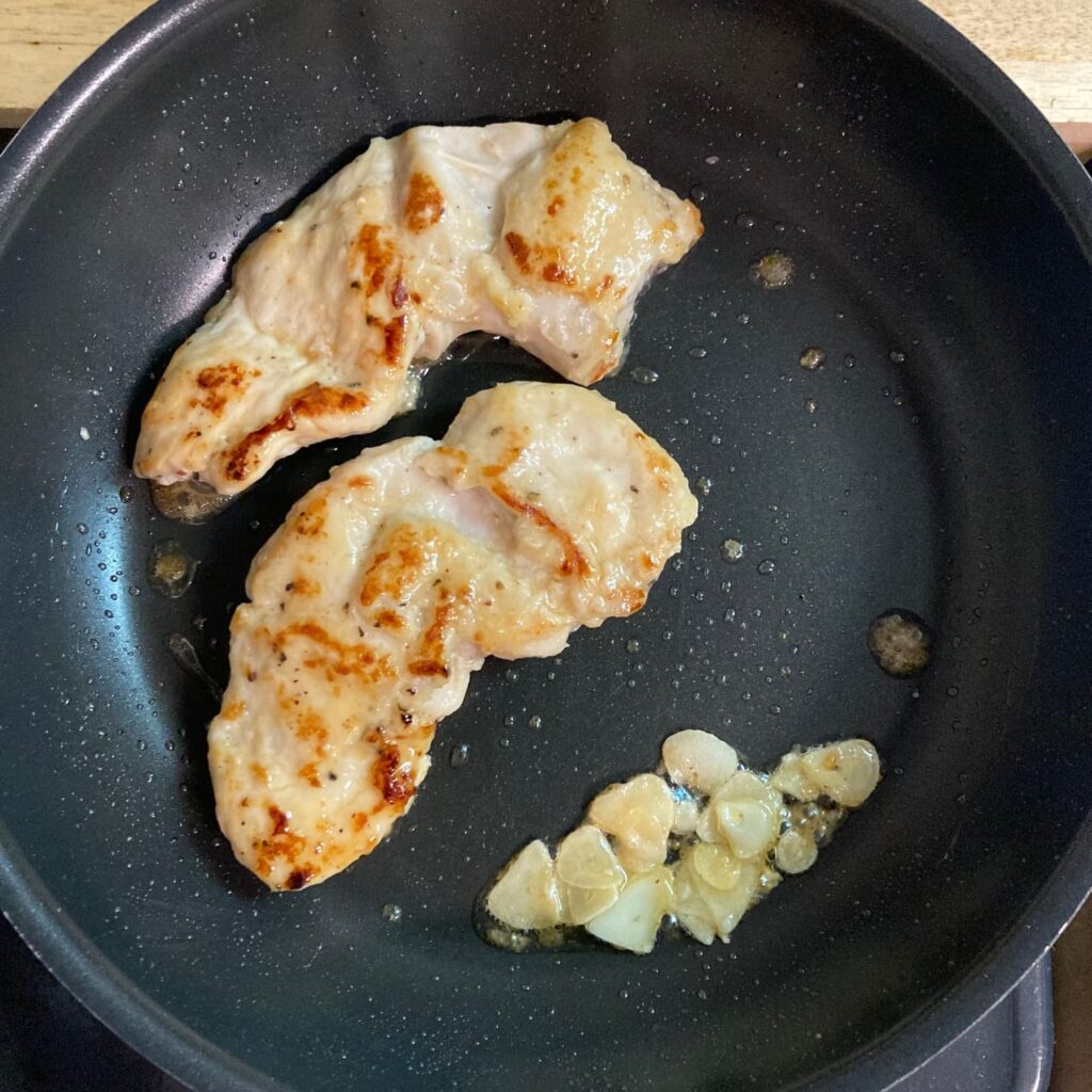 フライパンで焼いている鶏肉とにんにく