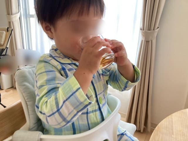 両手でつよいこグラスを持っている子供