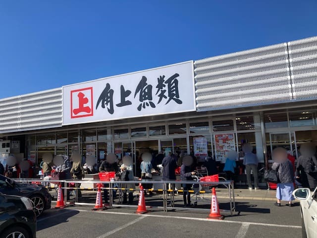 角上魚類の店前にいる大勢の人